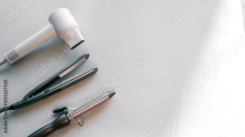 Photos Collection of professional hair styling tools including a hairdryer, straightene