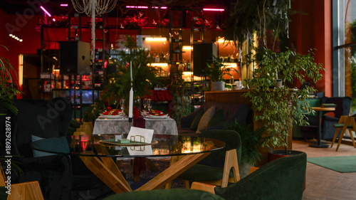 Tableau sur toile Elegant restaurant interior with lush greenery and candlelit dining tables