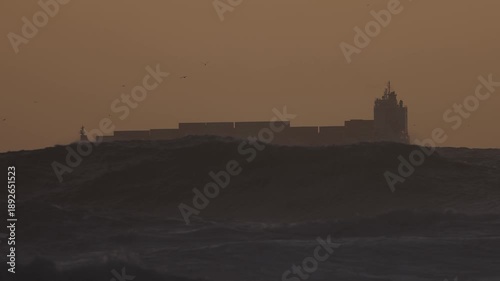 Cargo ship with containers on the ocean during a storm
