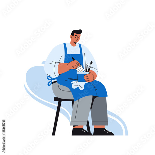 Male artist with blue apron painting on stool