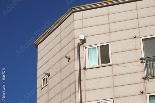 Gray building facade with windows under blue sky