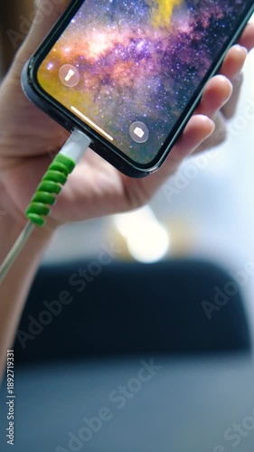 Close Up Hand Connecting Charging Cable to Smartphone.
