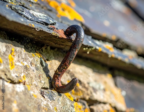 Rusty Hook on Stone Wall with Slate Roof Detail.