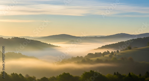 Soft misty mountain landscape with rolling hills and warm sunrise light creating a peaceful natural scenery ideal for travel inspiration nature backgrounds and calm atmospheric designs
