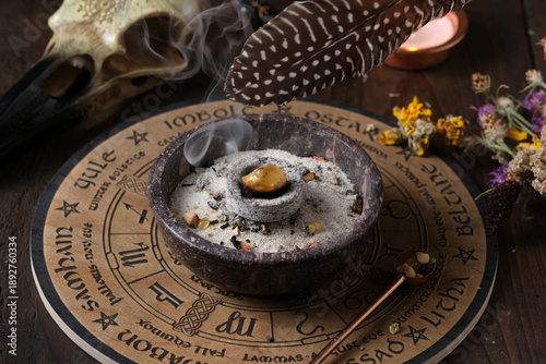 Tableau sur toile Close-up of a Wicca incense ritual – spreading sacred smoke with a feather