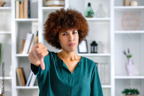 young black woman feeling cross, angry, annoyed, disappointed or displeased, showing thumb down with a serious look against home office