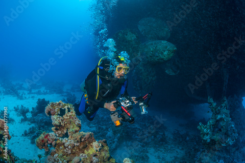 Tableau sur toile Scuba diver with underwater camera explores the interior of the sunken ferry Salem Express in the Red Sea