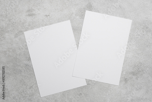 Two blank white cards on grey concrete background, ideal for greeting cards, wedding invitation or flyer designs presentation or minimalist stationery