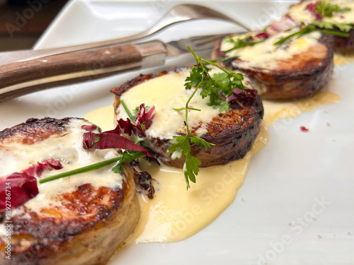 Appetizing lamb medallions from tender round pieces of tenderloin with creamy sauce in one of the French restaurants, Paris, France.