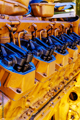 Close-up of Large Yellow Industrial Diesel Engine Cylinder Heads and Rocker Arm Assembly - Heavy Machinery Maintenance, Engineering and Power Generation Concept 1