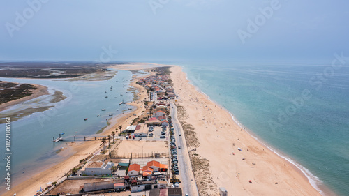 Aerial perspective of Ria Formosa and Praia de Faro captures the sandy beach, water, and nearby roads of this popular location in Portugal