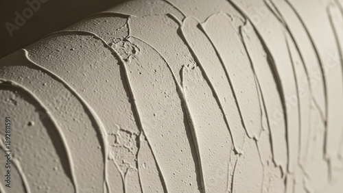 A close-up view of a textured, white, cylindrical surface with curved lines