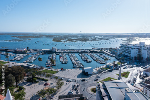 Tourists explore the Ria Formosa area in Faro, Algarve with its docks filled with boats and scenic views of the water and greenery