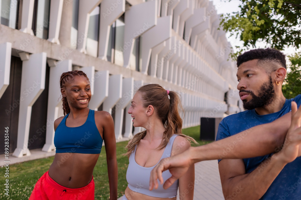 Fototapeta premium Diverse friends stretching together enjoying outdoor urban workout