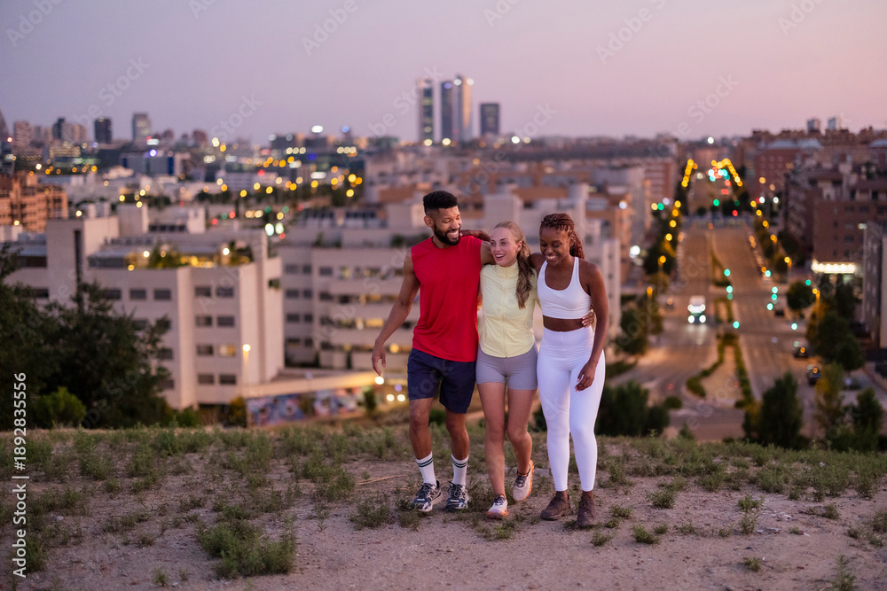 Obraz premium Diverse friends walking and smiling enjoying city views at dusk