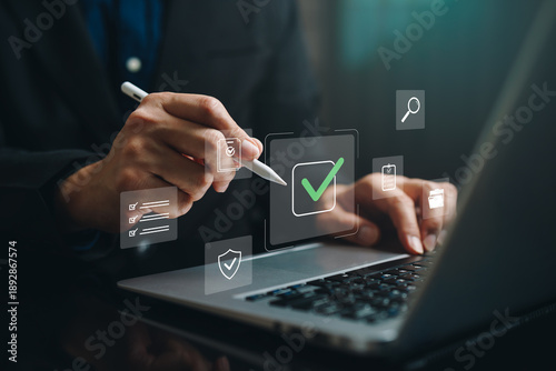 Hand using stylus on laptop with digital checkmark and checklist icon, representing approval workflow, task completion, compliance review, quality control, verification process, business management.