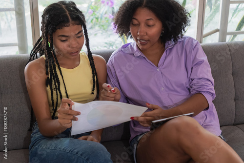 Black women students learning together studying paperwork