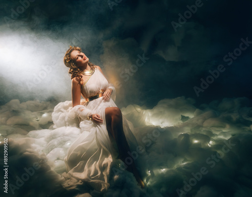 Fényképezés art photo real person fashion model, fantasy beauty woman goddess sitting in divine white soft clouds night sky magic rays light