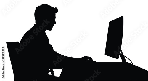 Silhouette of a man working on a computer at a desk