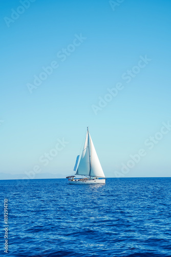Sailboat under clear blue sky on calm sea