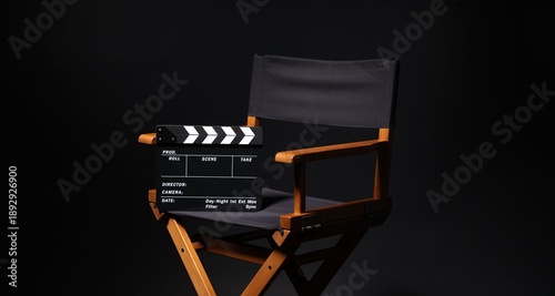 Canvas Print Film director's chair with clapperboard on black background, closeup