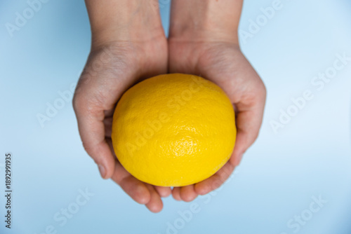 Hand holding very large fresh lemon