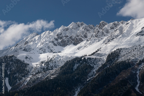 Snow-covered Nordkette above Innsbruck, Austria – winter alpine ridge with clouds and ski resort slopes