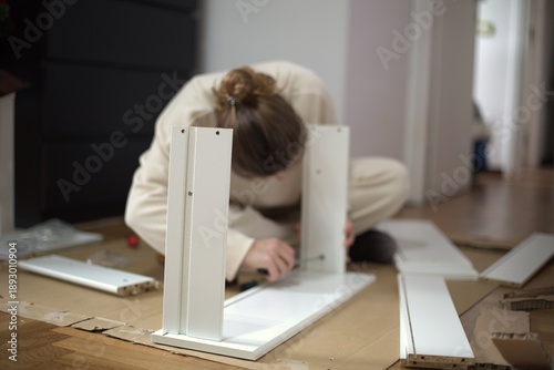 Obraz na plátne Woman assembling flat pack furniture at home