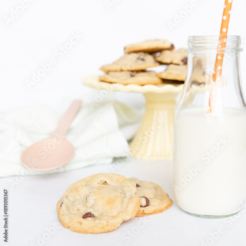 Cookies on platter with glass of milk and straw