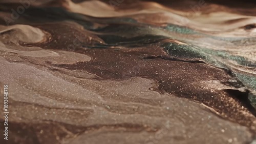 Abstract fluid art with brown, green, and gold colors, wavy patterns.