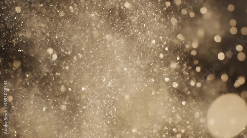 Abstract golden glitter particles floating in the air, creating a magical effect.