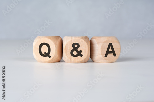 Q and A letters on wooden cubes on white background