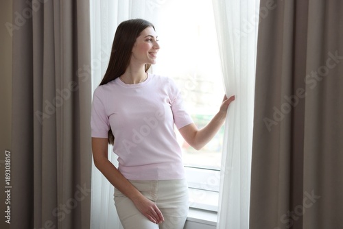 Happy woman opening window curtains at home Free Download Happy woman opening window curtains at home - GFXLoad