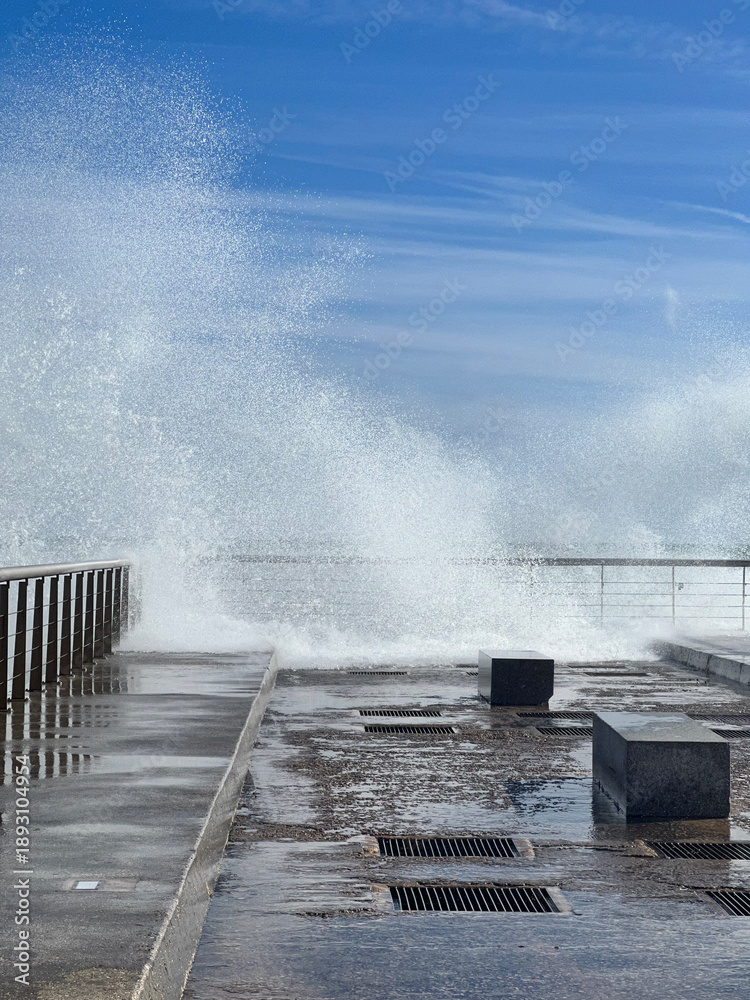 Fototapeta premium wave crashing on pier with blue sky, copyspace for banner, travel