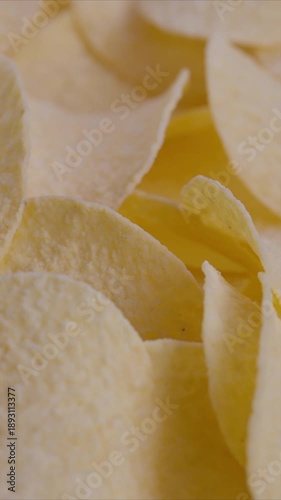 Closeup of crunchy salted potato crisps under warm light, Photographic capture of crispy salted potato chips with visible grains and inviting warm studio illumination