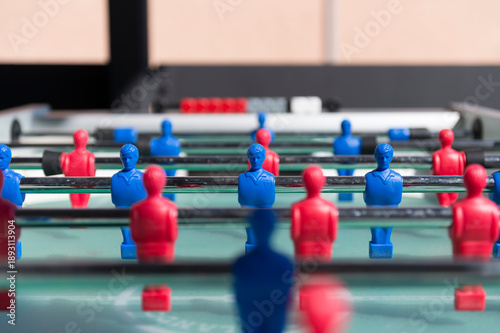 Foosball table close-up with red and blue players, indoor game and teamwork competition concept