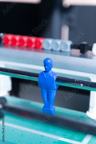 Blue foosball player figure in close-up with score counter, table football game detail and competition concept