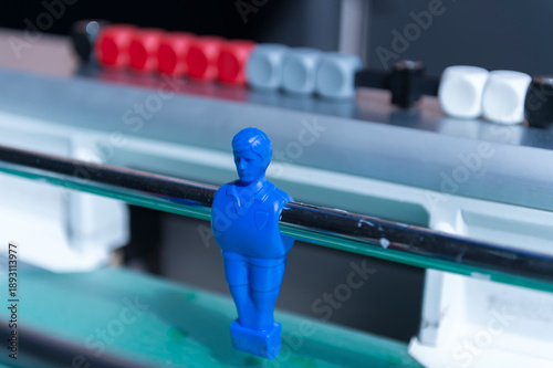 Blue foosball player figure in close-up with score counter, table football game detail and competition concept