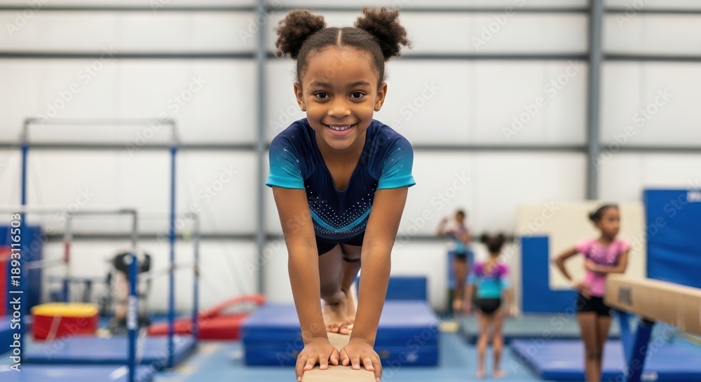 Fototapeta premium young girl balancing on gymnastics beam in indoor training facility with a joyful expression