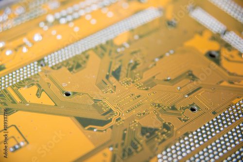 Golden printed circuit board macro with electronic traces and bokeh, abstract technology background