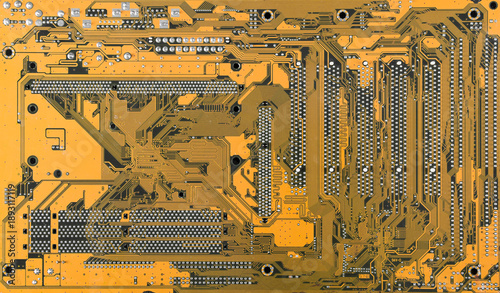 Yellow/Orange printed circuit board back side with copper traces and solder points, high detail electronics motherboard texture background