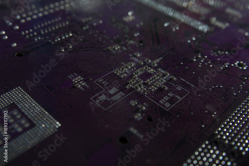 Dark purple printed circuit board macro with solder points and electronic traces, abstract high tech background