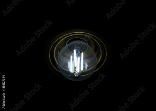 Lampadina led accesa con filamenti incandescenti in portalampade color ottone