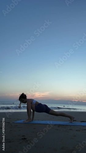 Woman practicing yoga on the beach during a beautiful sunrise
