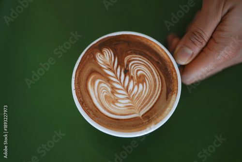 Moccacino in a woman hand, top view.