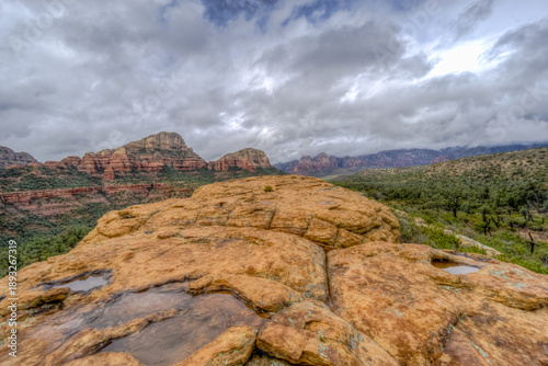 Tableau sur toile A rocky mountain top with a cloudy sky in the background