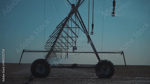 A modern center pivot irrigation system operating on an open agricultural field. Sprinkler nozzles evenly distribute water across the soil surface, ensuring optimal moisture levels.