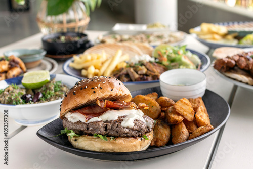 Wallpaper Mural Gourmet wagyu beef burger wirh bacon, cheese and wedge fries on outdoor white cafe table Torontodigital.ca