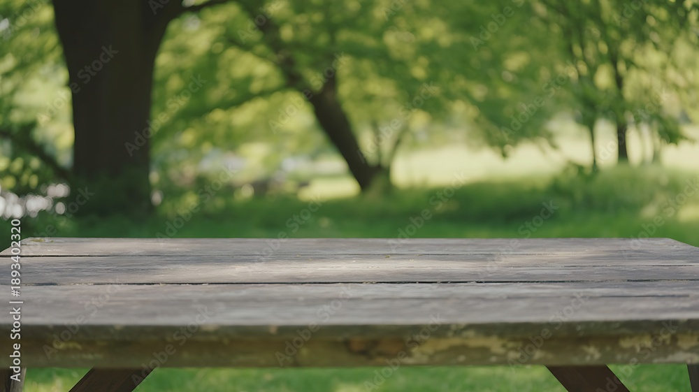 Naklejka premium Wooden picnic table in a lush green park with trees