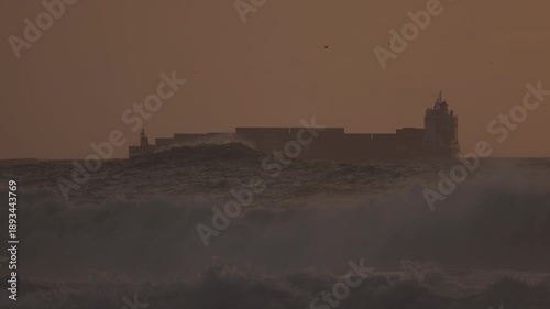 Cargo ship with containers on the ocean during sunset